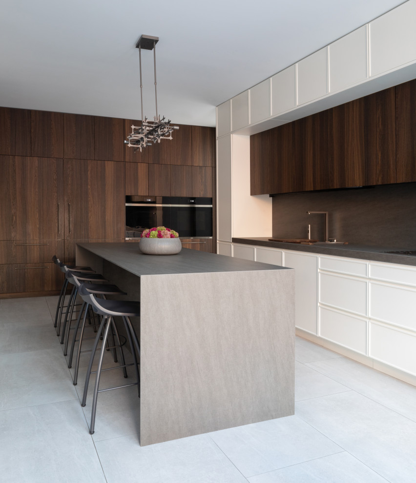 Expansive contemporary u-shaped eat-in kitchen in New York with an undermount sink, grey splashback, panelled appliances, porcelain floors, with island, grey floor, grey benchtop, flat-panel cabinets, medium wood cabinets and quartz benchtops.