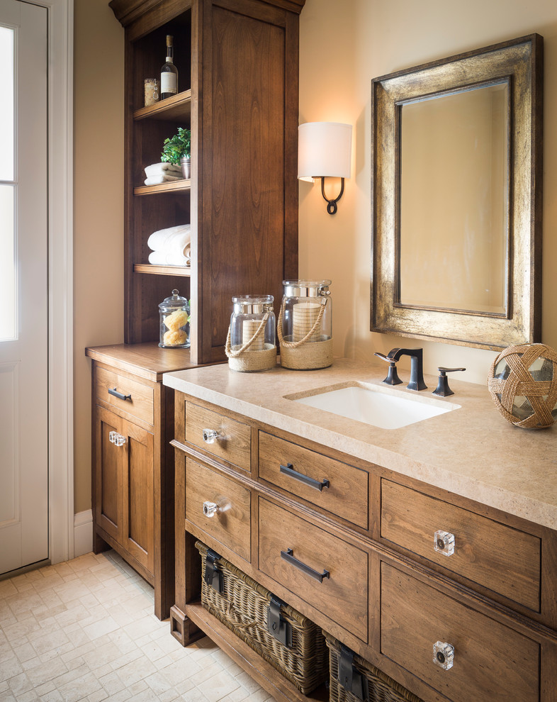 Photo of a mid-sized arts and crafts bathroom in San Francisco with flat-panel cabinets, medium wood cabinets, beige walls, mosaic tile floors, an undermount sink and limestone benchtops.