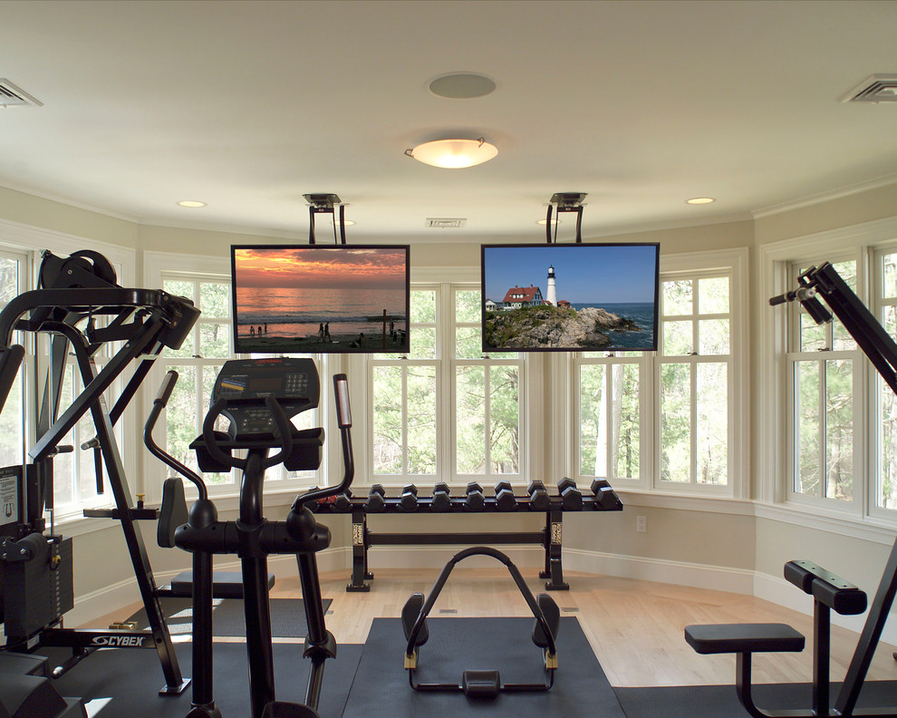 This is an example of a mid-sized contemporary home weight room in Boston with beige walls, light hardwood floors and beige floor.