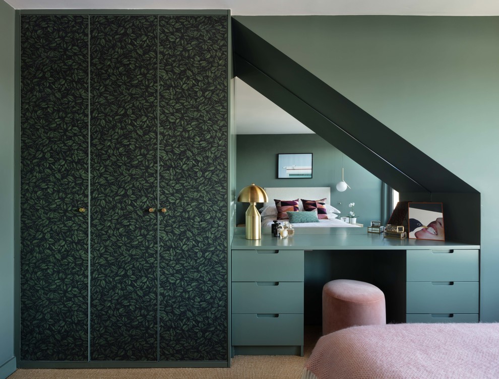 Mid-sized contemporary master bedroom in London with green walls, carpet and brown floor.