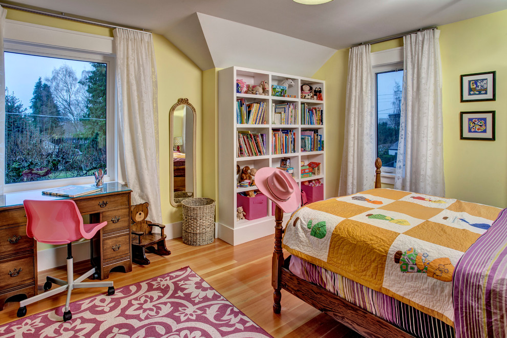 Mid-sized country kids' bedroom in Seattle with yellow walls and medium hardwood floors for kids 4-10 years old and girls.