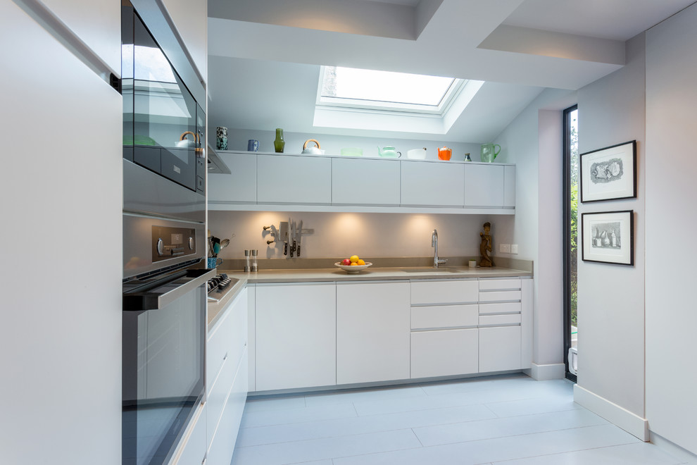 Photo of a mid-sized transitional l-shaped eat-in kitchen in London with limestone benchtops, blue splashback, cement tile splashback, painted wood floors, no island, white floor and beige benchtop.