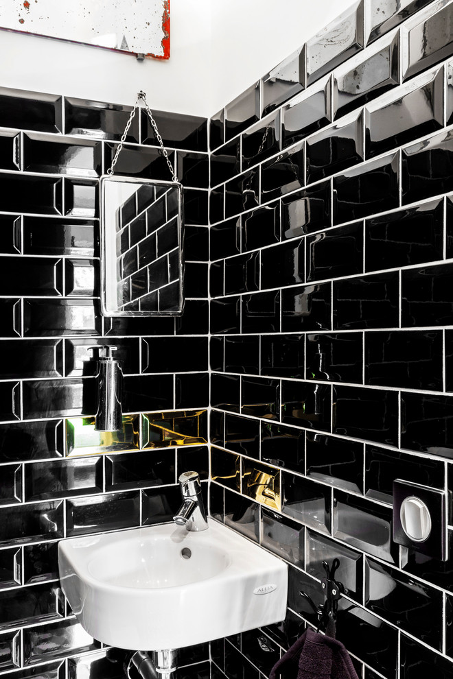 Inspiration for a small contemporary powder room in Paris with a wall-mount sink, subway tile and black tile.