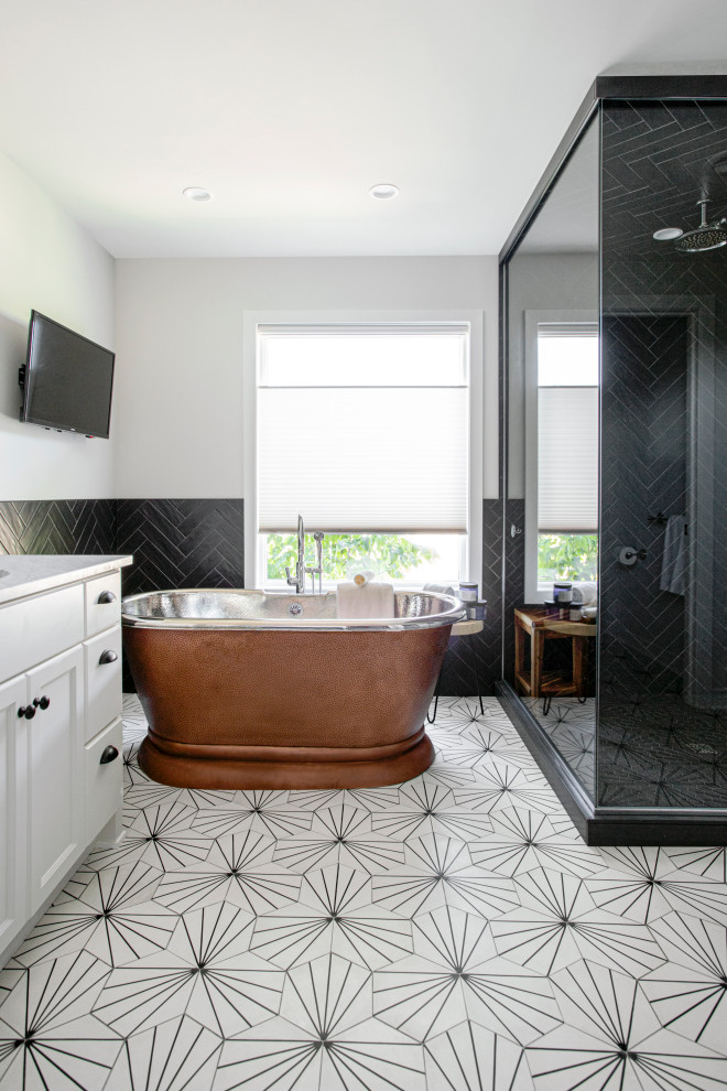 Photo of a small transitional master bathroom in Minneapolis with raised-panel cabinets, white cabinets, a freestanding tub, a corner shower, a one-piece toilet, black tile, stone tile, white walls, cement tiles, an undermount sink, marble benchtops, white floor, a hinged shower door, white benchtops, a niche, a double vanity and a built-in vanity.