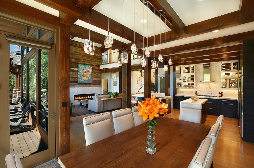 Photo of a large arts and crafts open plan dining in Salt Lake City with white walls, light hardwood floors, a standard fireplace and a stone fireplace surround.