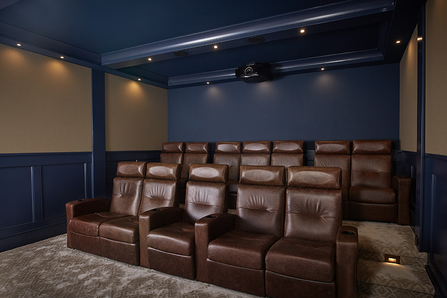 Design ideas for a mid-sized transitional enclosed home theatre in Grand Rapids with blue walls, carpet, a projector screen and brown floor.