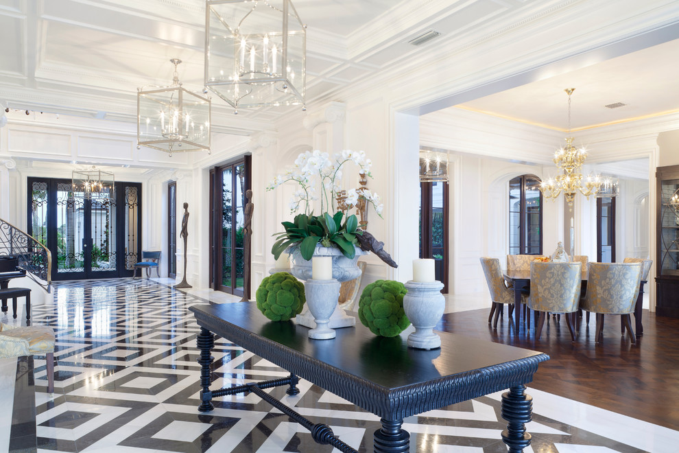 Example of a huge transitional marble floor entryway design in Miami with white walls and a black front door