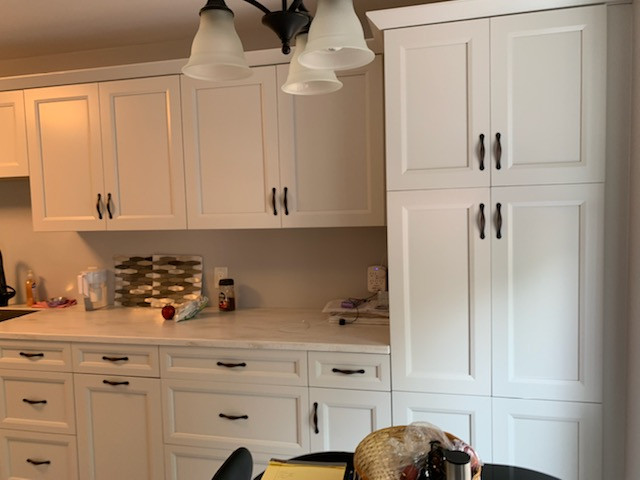Mid-sized transitional galley enclosed kitchen photo with a drop-in sink, gray cabinets, solid surface countertops, no island, white countertops, black appliances and recessed-panel cabinets