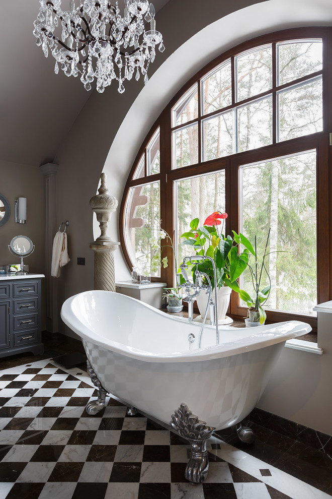 This is an example of a traditional bathroom in Other with grey cabinets, a claw-foot tub, black and white tile, grey walls and recessed-panel cabinets.