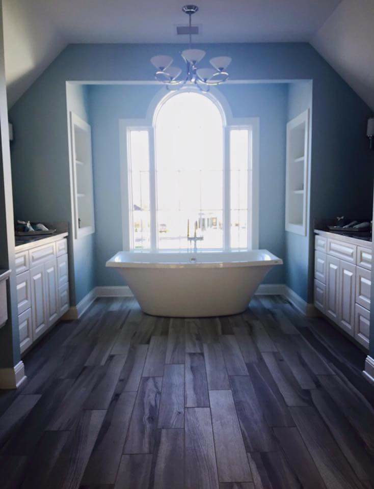 Design ideas for a large traditional master bathroom in New York with white cabinets, blue walls, dark hardwood floors, laminate benchtops, raised-panel cabinets, a freestanding tub and an undermount sink.