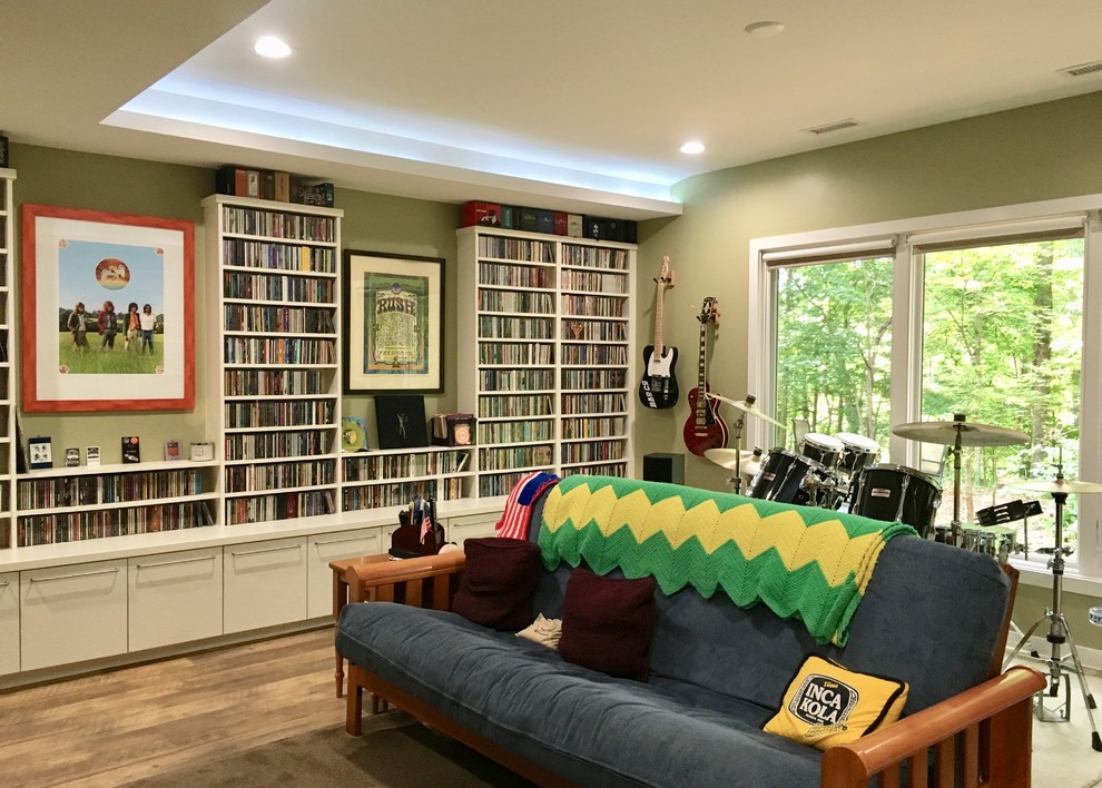 This is an example of a mid-sized contemporary enclosed family room in Raleigh with green walls, vinyl floors, a wall-mounted tv, brown floor and a music area.