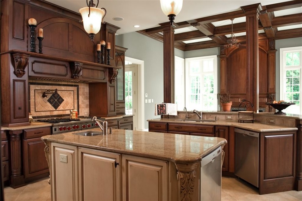 This is an example of a large transitional u-shaped eat-in kitchen in Raleigh with an undermount sink, raised-panel cabinets, dark wood cabinets, granite benchtops, beige splashback, ceramic splashback, stainless steel appliances, ceramic floors, multiple islands, beige floor and brown benchtop.