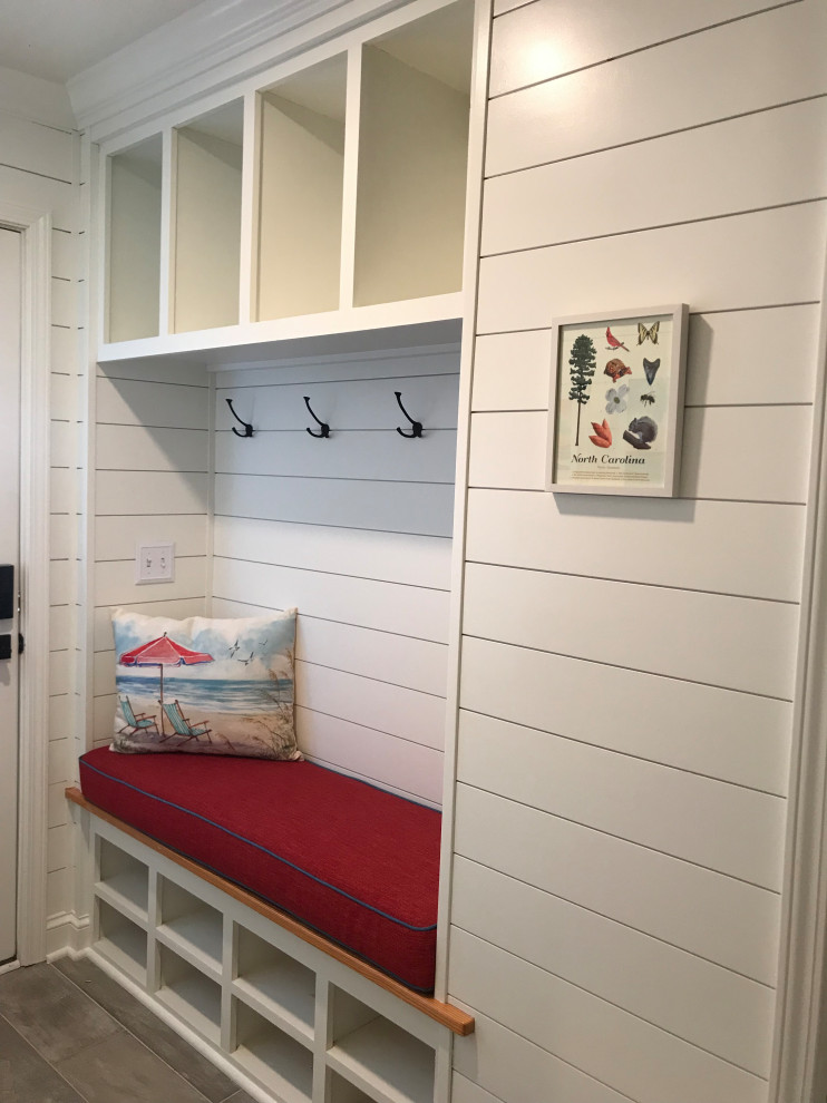 Inspiration for a small beach style mudroom in Other with light hardwood floors, beige floor and planked wall panelling.
