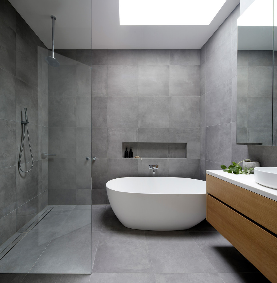 Inspiration for a modern ensuite bathroom in Melbourne with beige cabinets, a freestanding bath, a walk-in shower, grey tiles, porcelain tiles, grey walls, porcelain flooring, engineered stone worktops, an open shower, a wall niche and a floating vanity unit.