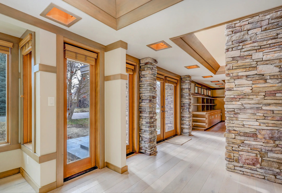 Inspiration for a light wood floor, brown floor and vaulted ceiling double front door remodel with a medium wood front door