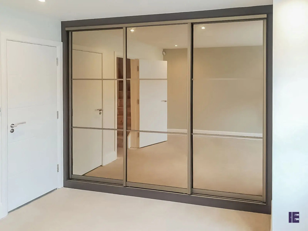 This is an example of a small contemporary storage and wardrobe in London with flat-panel cabinets and brown cabinets.