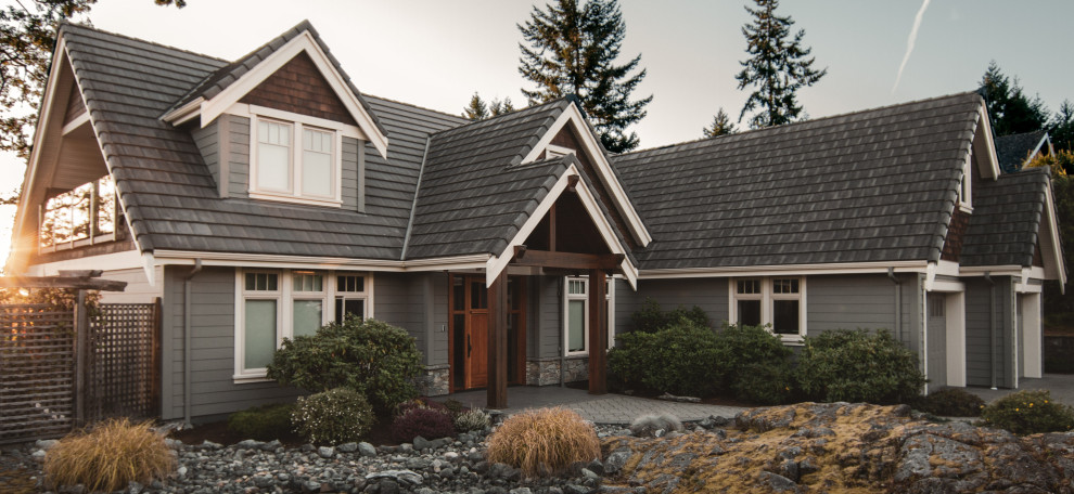 Inspiration pour une façade de maison grise traditionnelle en panneau de béton fibré et bardage à clin de taille moyenne et à un étage avec un toit en tuile et un toit gris.