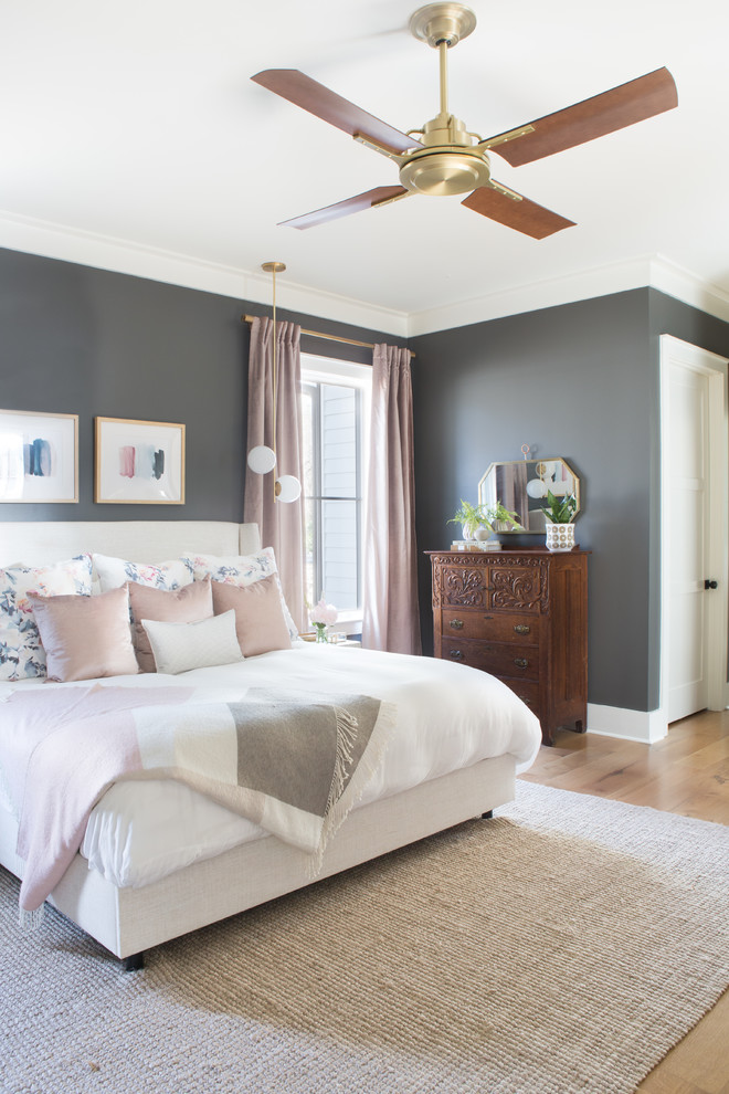 Mid-sized transitional master bedroom in Other with grey walls and light hardwood floors.