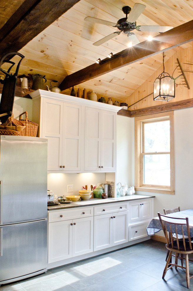 Mid-sized country galley separate kitchen in Minneapolis with an undermount sink, shaker cabinets, white cabinets, quartz benchtops, white splashback, subway tile splashback, stainless steel appliances, porcelain floors and no island.