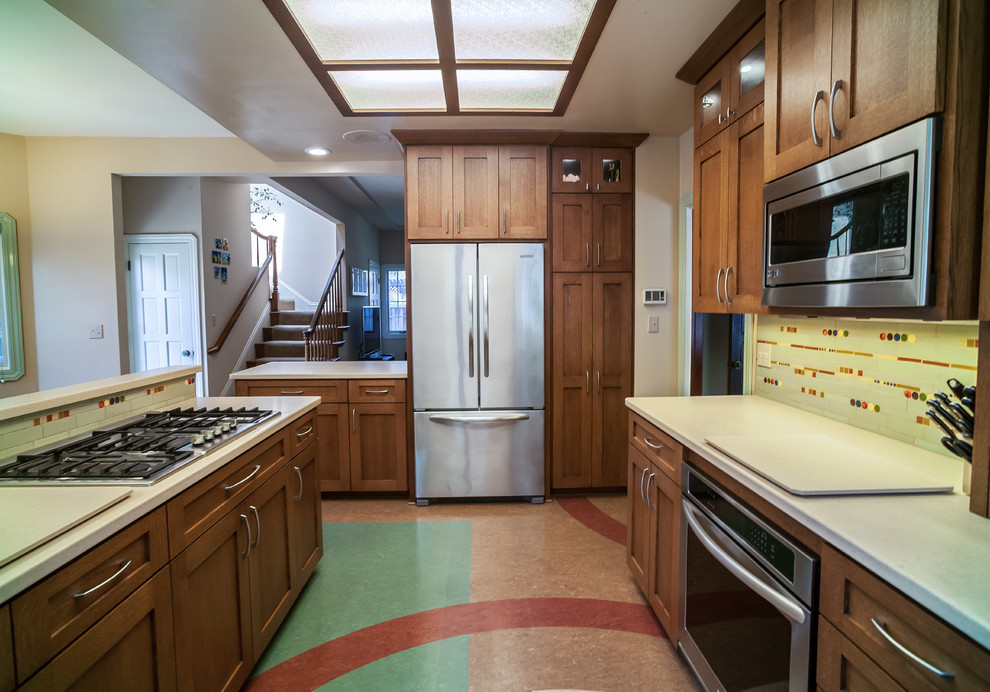 Inspiration for a mid-sized midcentury u-shaped separate kitchen in San Francisco with shaker cabinets, medium wood cabinets, quartz benchtops, glass tile splashback, stainless steel appliances, with island, multi-coloured floor and white benchtop.