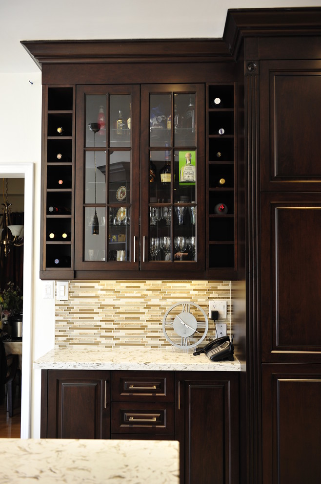 Example of a mid-sized transitional u-shaped eat-in kitchen design in Toronto with a double-bowl sink, raised-panel cabinets, dark wood cabinets, quartz countertops, multicolored backsplash, matchstick tile backsplash, stainless steel appliances and a peninsula