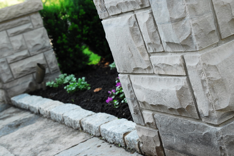 This is an example of a large rustic full sun front yard stone formal garden in Toronto for summer.