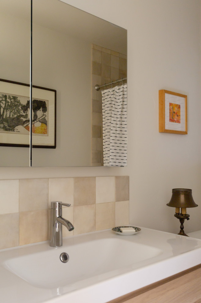 Idee per una stanza da bagno nordica con ante lisce, ante in legno chiaro, vasca da incasso, piastrelle beige, pavimento in gres porcellanato, top bianco, un lavabo e mobile bagno sospeso