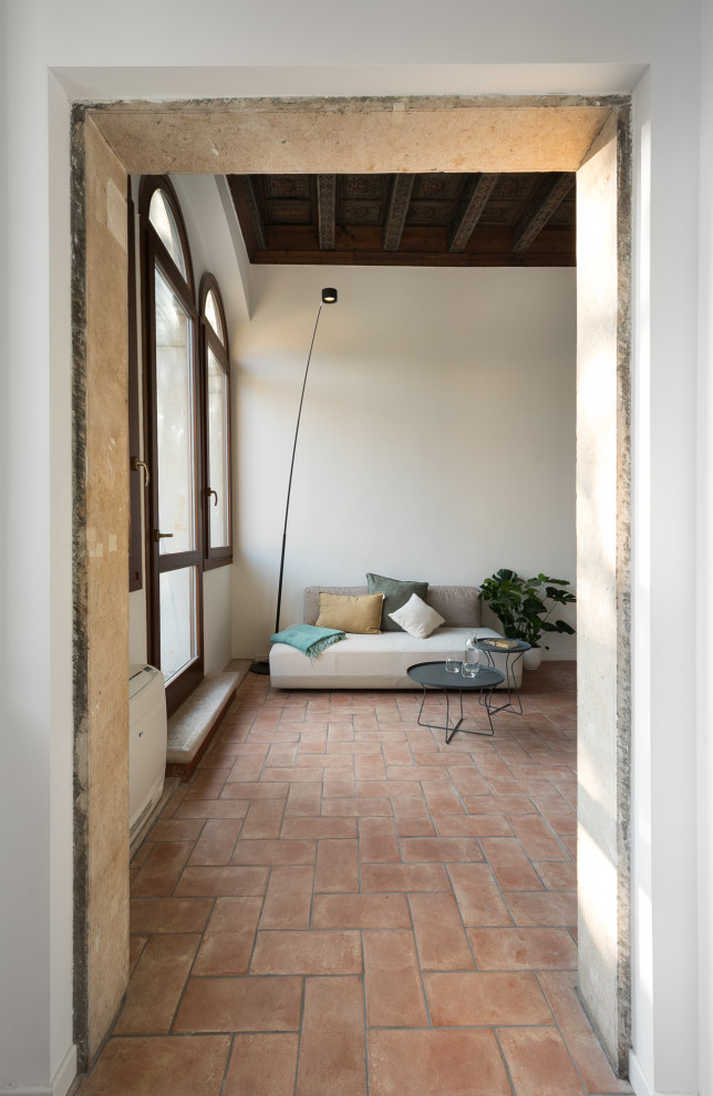 Immagine di un piccolo ingresso o corridoio design con pareti bianche, pavimento in mattoni, pavimento rosso e soffitto ribassato
