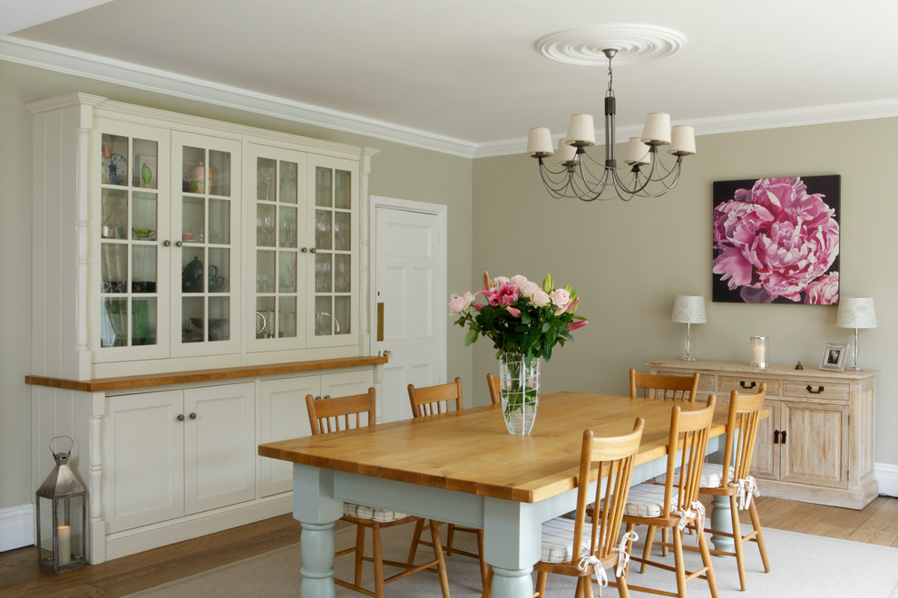 Design ideas for a mid-sized country separate dining room in Other with green walls and light hardwood floors.
