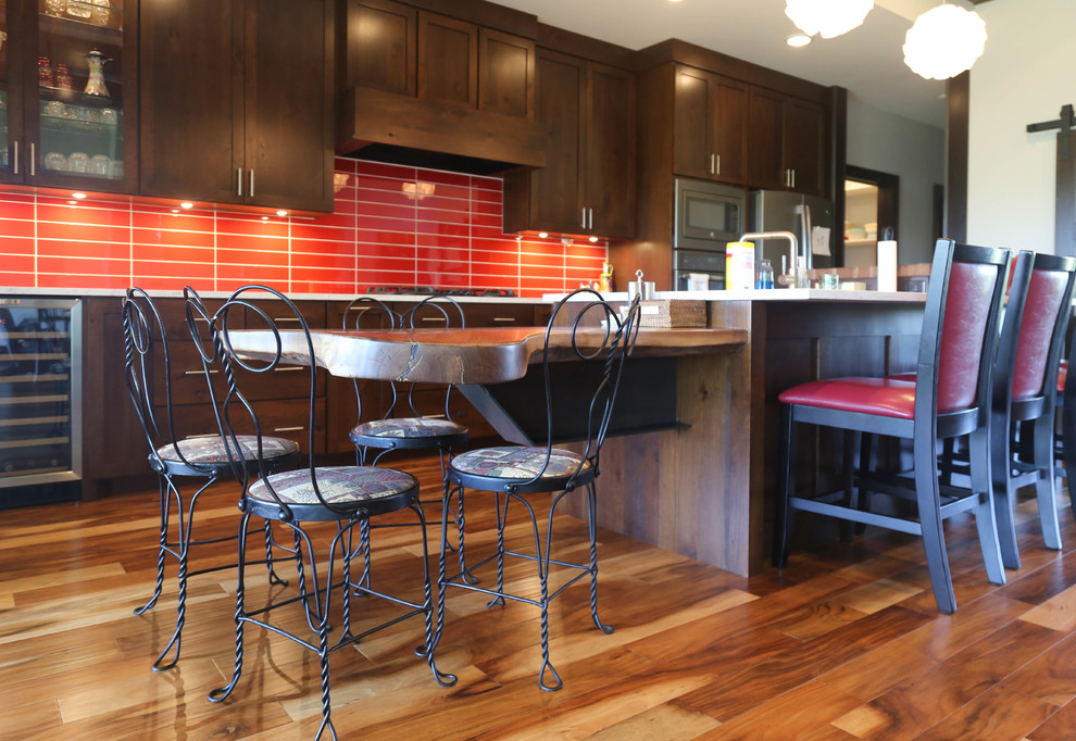 Mid-sized transitional galley medium tone wood floor and brown floor eat-in kitchen photo with an undermount sink, recessed-panel cabinets, medium tone wood cabinets, quartzite countertops, red backsplash, glass tile backsplash, stainless steel appliances and an island