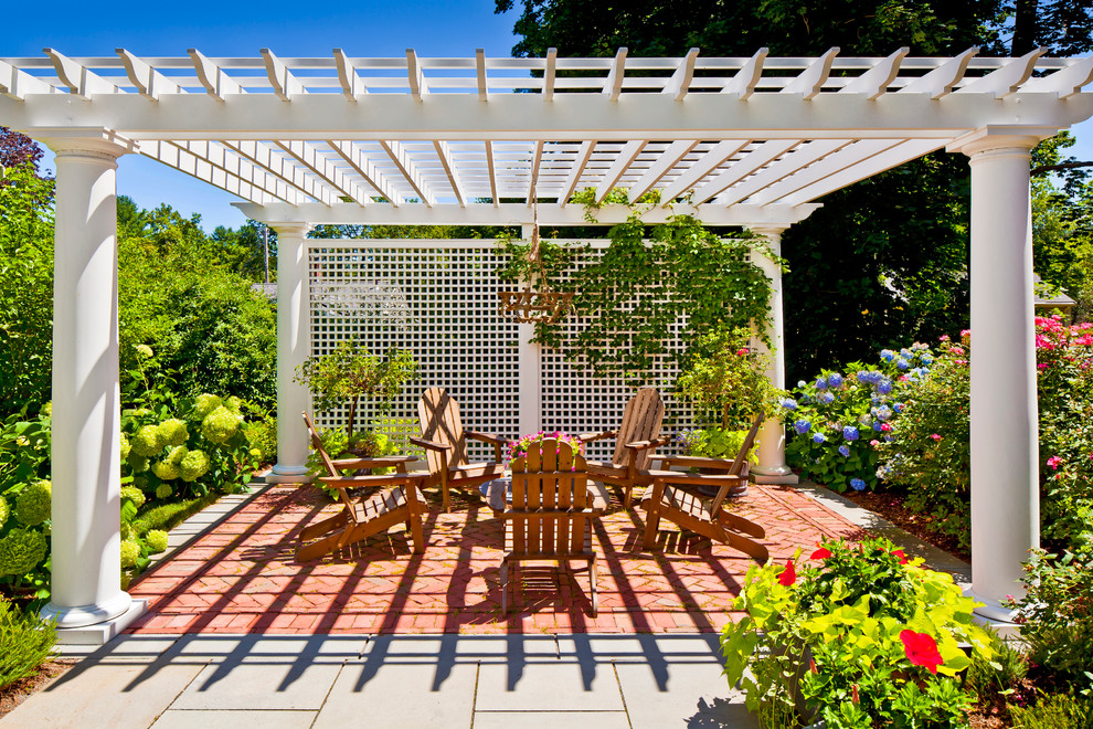 This is an example of a traditional patio in Boston with brick pavers, a vertical garden and a gazebo/cabana.