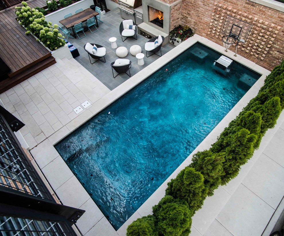 Photo of a small modern courtyard rectangular lap pool in Chicago with a hot tub and natural stone pavers.