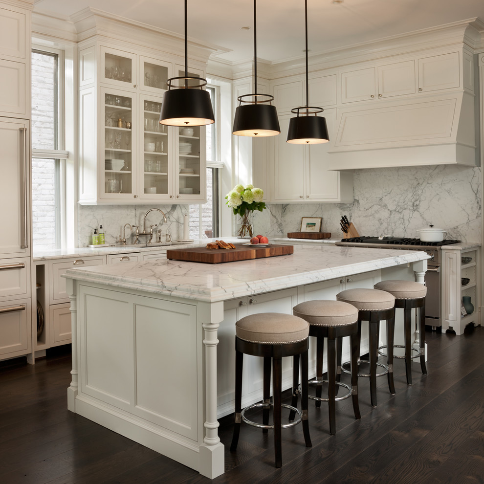 Transitional l-shaped kitchen in DC Metro with an undermount sink, recessed-panel cabinets, white cabinets, marble benchtops, white splashback, stone slab splashback, panelled appliances, dark hardwood floors and with island.