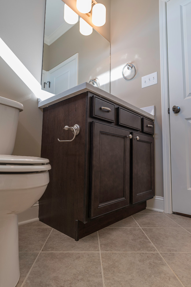 Example of a mid-sized transitional kids' beige tile and ceramic tile ceramic tile alcove bathtub design with shaker cabinets, black cabinets, a two-piece toilet, beige walls, an undermount sink and solid surface countertops