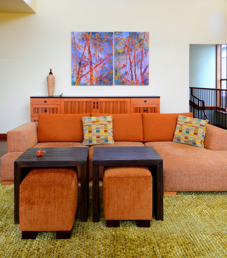 Large eclectic enclosed living room in Seattle with yellow walls, medium hardwood floors, a standard fireplace and a tile fireplace surround.