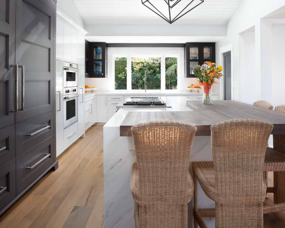Example of a transitional eat-in kitchen design in Orange County with an island