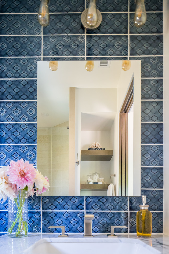 Inspiration for a large mediterranean shower room bathroom in Orange County with open cabinets, an alcove shower, blue tiles, white walls, a submerged sink, a hinged door and white worktops.