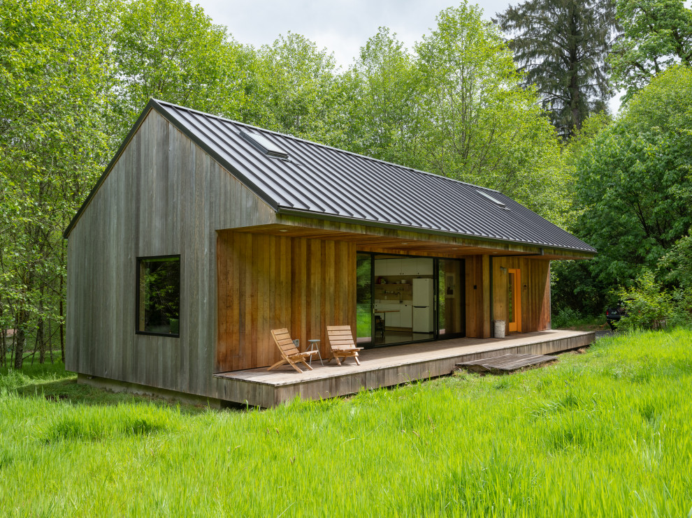 Exemple d'une petite façade de maison montagne en bois de plain-pied avec un toit à deux pans, un toit en métal et un toit gris.