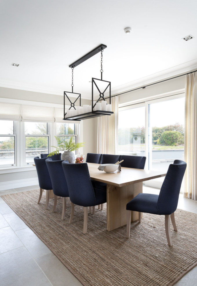This is an example of a large beach style open plan dining in Dublin with beige walls, limestone floors and grey floor.