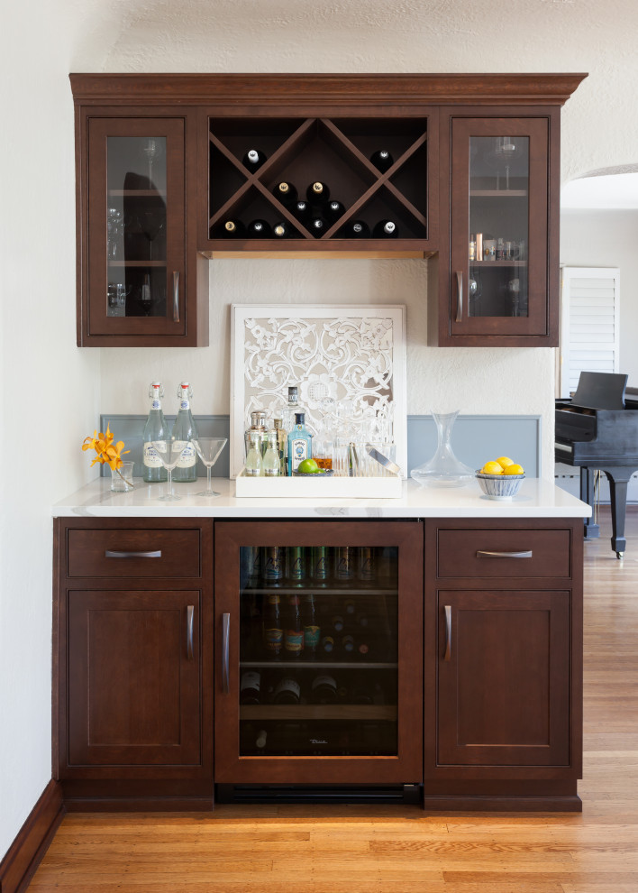 Small transitional single-wall home bar in Seattle with shaker cabinets, medium wood cabinets, medium hardwood floors, brown floor and white benchtop.