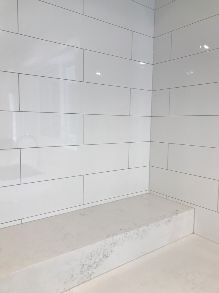 Example of a mid-sized transitional porcelain tile and brown floor home design design in Toronto with an undermount sink, shaker cabinets, gray cabinets, quartz countertops, white backsplash, subway tile backsplash, stainless steel appliances, an island and white countertops