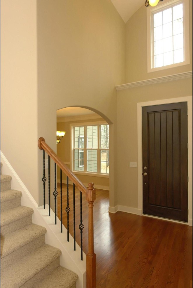 Photo of a large traditional foyer in Raleigh with beige walls, medium hardwood floors, a single front door and a dark wood front door.