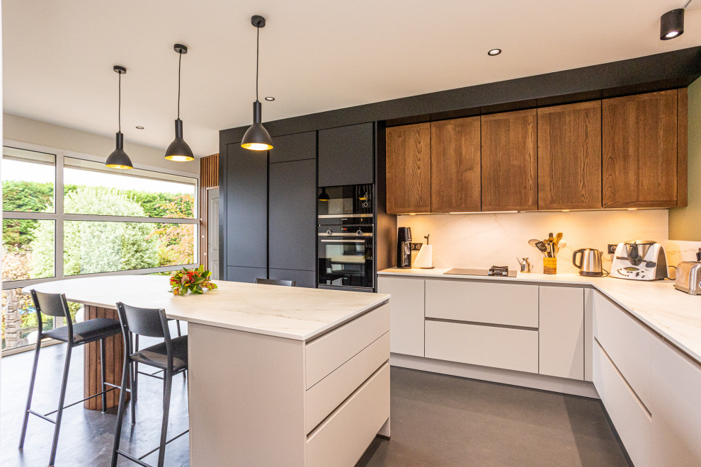 This is an example of a large contemporary l-shaped separate kitchen in Bordeaux with an undermount sink, beaded inset cabinets, black cabinets, marble benchtops, beige splashback, marble splashback, stainless steel appliances, concrete floors, with island, grey floor and beige benchtop.