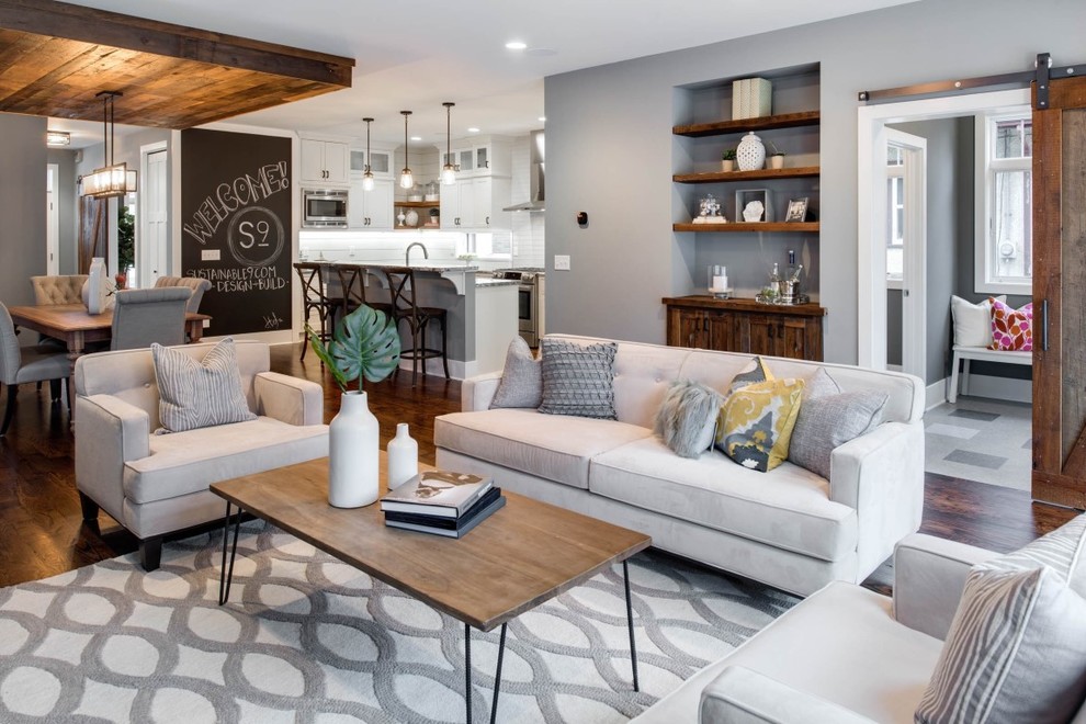 This is an example of a mid-sized transitional formal open concept living room in Minneapolis with grey walls, medium hardwood floors, a standard fireplace, a tile fireplace surround and a wall-mounted tv.