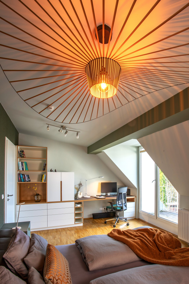 Foto di uno studio minimal con pareti verdi, moquette, scrivania incassata e pavimento marrone