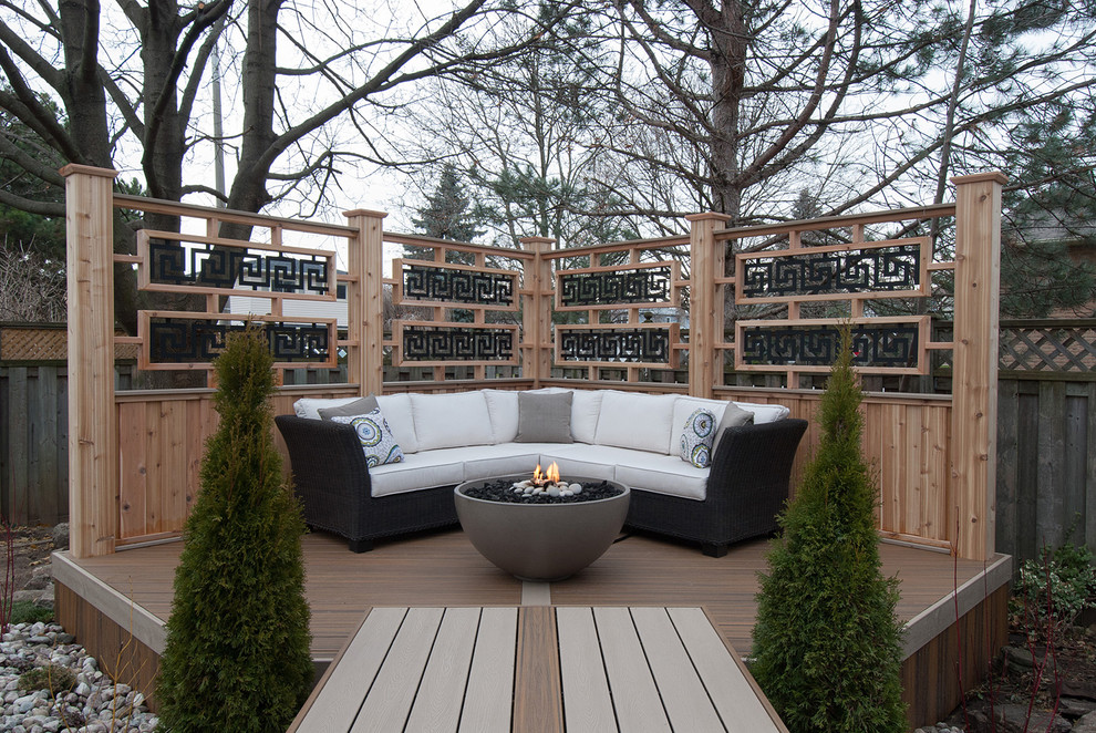 Photo of a mid-sized traditional backyard deck in Toronto with a fire feature and a pergola.