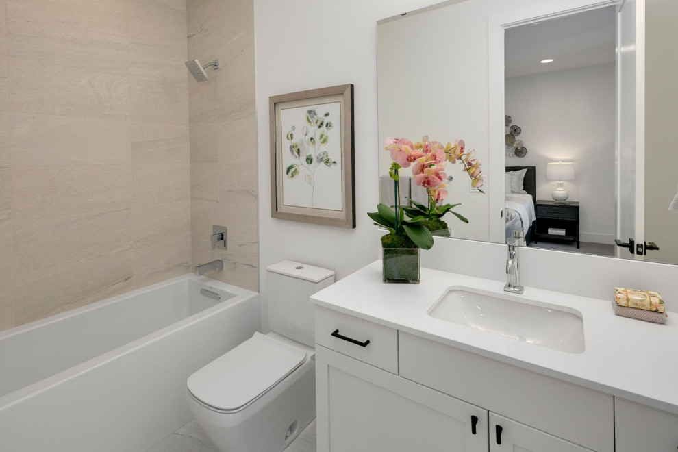 Design ideas for a mid-sized country bathroom in Seattle with recessed-panel cabinets, white cabinets, a shower/bathtub combo, a one-piece toilet, beige tile, porcelain tile, beige walls, an undermount sink, engineered quartz benchtops, grey floor, an open shower, white benchtops, a single vanity and a built-in vanity.