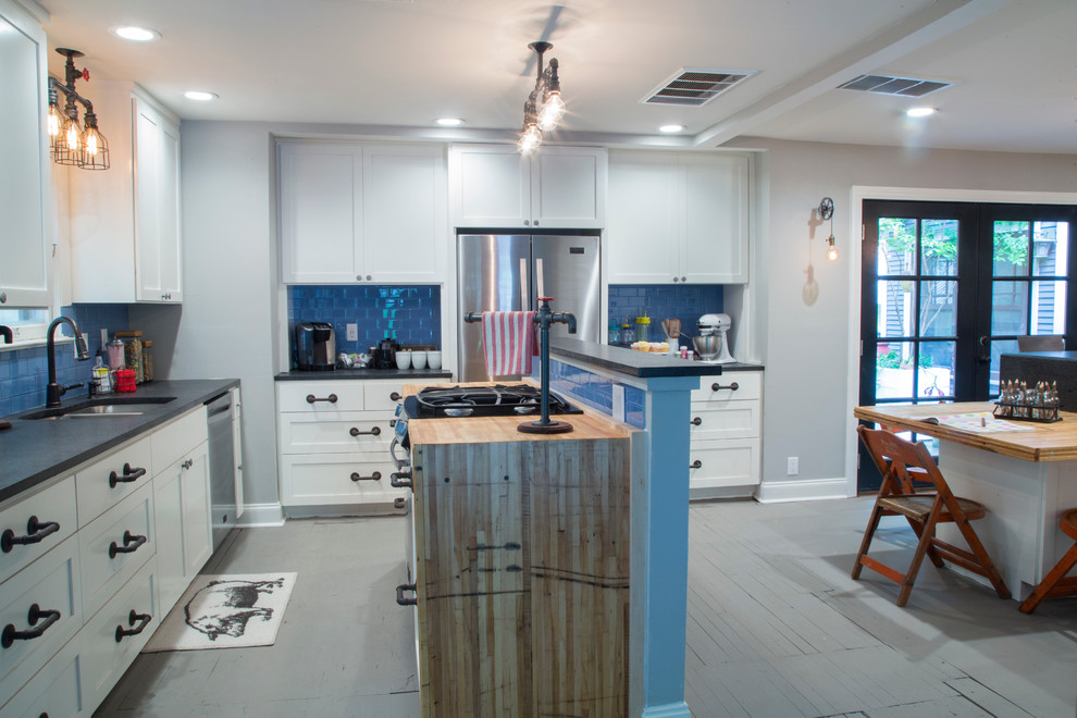 This is an example of an industrial l-shaped eat-in kitchen in New York with an undermount sink, shaker cabinets, white cabinets, quartz benchtops, blue splashback, ceramic splashback, stainless steel appliances, painted wood floors and with island.