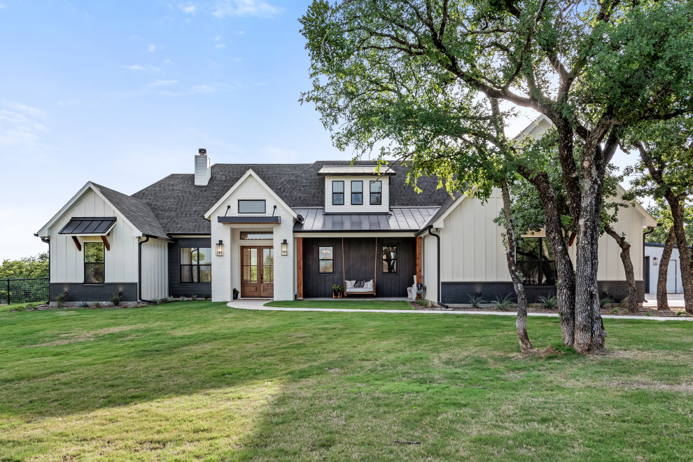 Mid-sized country one-storey white house exterior in Dallas with mixed siding, a mixed roof, a grey roof and board and batten siding.