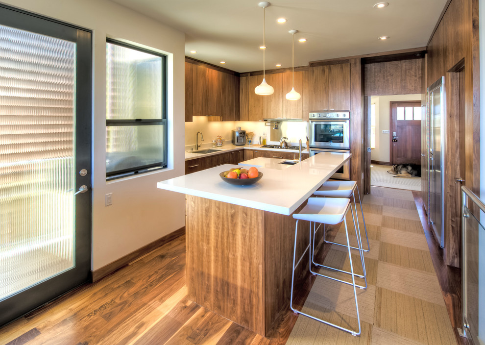 Inspiration for a contemporary l-shaped open plan kitchen in San Francisco with stainless steel appliances, a single-bowl sink, flat-panel cabinets, medium wood cabinets, quartzite benchtops, medium hardwood floors and with island.